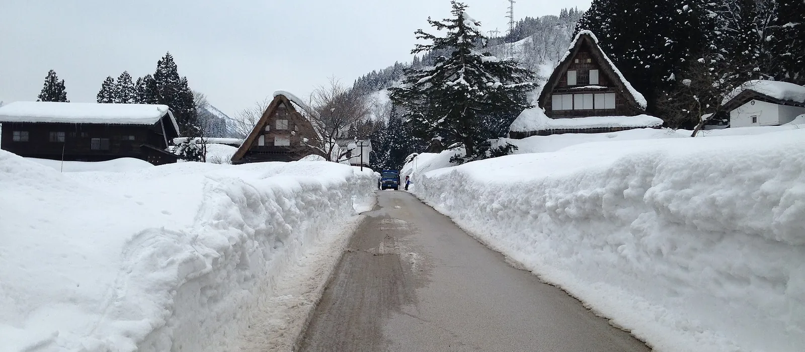 両側に雪の壁ができた道と、屋根に雪を載せた家並み(南砺市五箇山・相倉集落)
