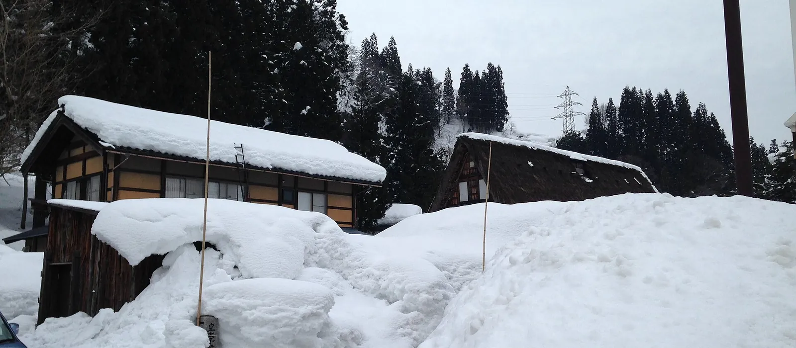 屋根の上まで雪が積もり、軒先まで雪に埋もれた木造の家屋が並ぶ南砺市五箇山相倉の集落