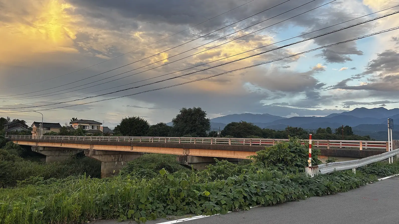 夕暮れの滑川市、川に架かる橋と川沿いの住宅