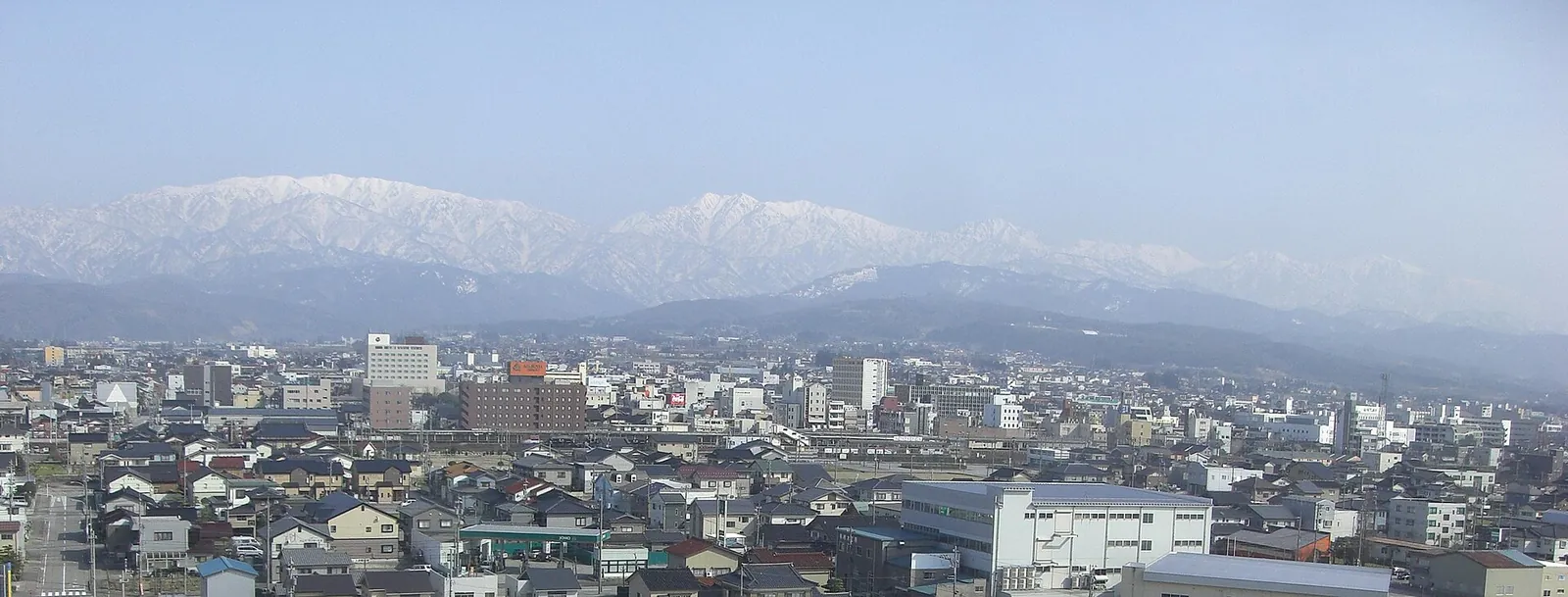 魚津市街の家並みと残雪の山並み