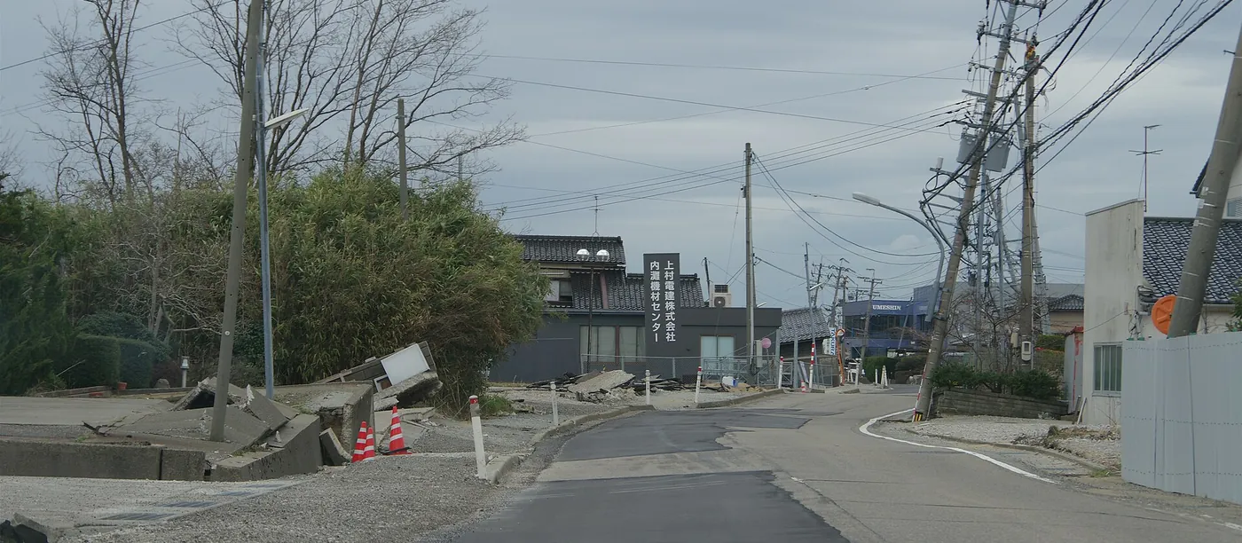 2024年能登半島地震の液状化で路面が盛り上がって割れ、電柱が傾いた石川県内灘町宮坂地区の道路
