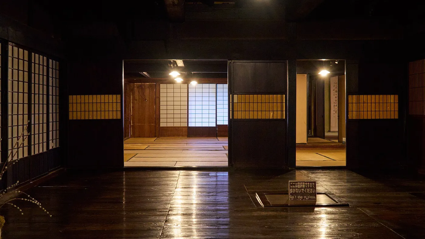 黒く使い込まれた板の間の奥に、障子で仕切られた畳の部屋が続く古民家の内部(岐阜県高山市)